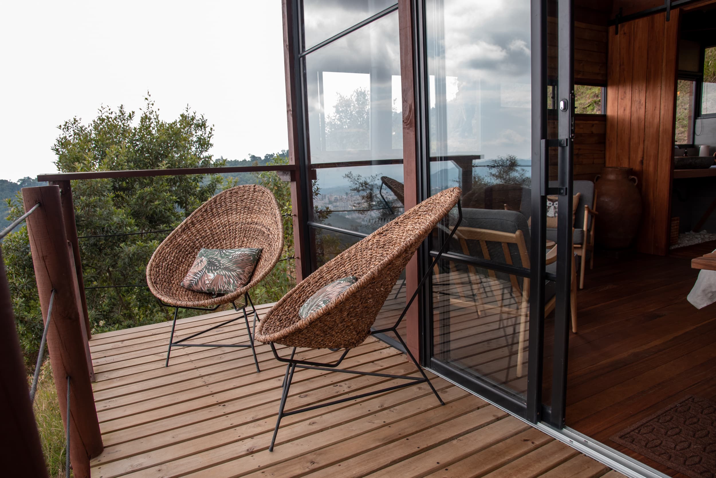Balcony with woven chairs and valley view